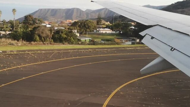 Tenerife, Spain - November 24, 2021: Ryanair plane landing at Tenerife Norte Airport in Canary Islands - view from the airplane window. Video 54 seconds. Airplane wing moves over volcanic landscapes