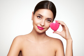 Young beautiful woman with heart-shaped gift. Girl with pure perfect face skin. Cosmetology, beauty...