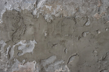 Rough dark gray relief plastered wall.