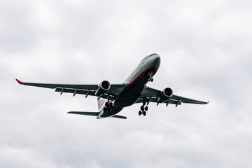 Passenger plane comes in for landing in cloudy weather.