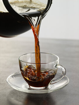Coffee being Poured into Glass Cup and Saucer