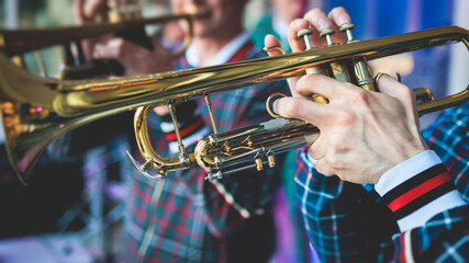 Concert view of a male trumpeter, professional trumpet player with vocalist and musical during jazz band performing