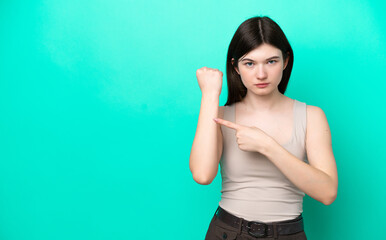 Young Russian woman isolated on green background making the gesture of being late