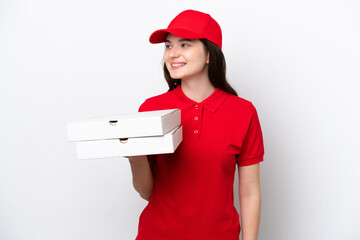 Young Russian pizza delivery picking up pizza boxes isolated on white background looking side