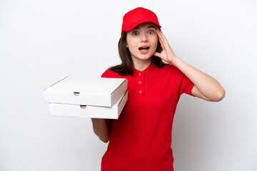 Young Russian pizza delivery picking up pizza boxes isolated on white background with surprise...
