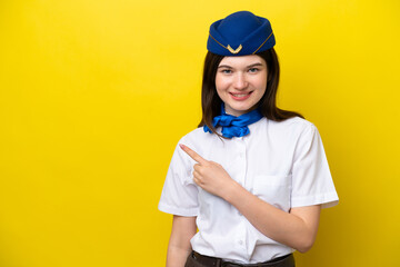 Airplane stewardess Russian woman isolated on yellow background pointing to the side to present a product