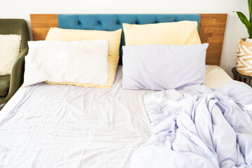Comfort and Untidy Bed with Pillows and Duvet. The Pastel Color themed sheets and pillows were ruined after a night's sleep.