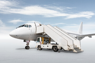 Fototapeta na wymiar White passenger airliner with a boarding stairs isolated on bright background with sky