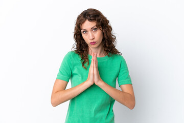 Young woman with curly hair isolated on white background keeps palm together. Person asks for something