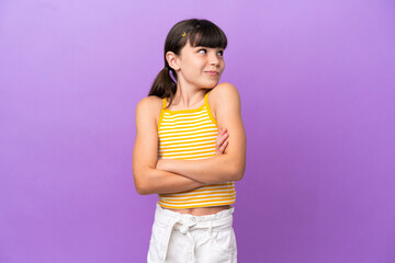 Little caucasian kid isolated on purple background making doubts gesture while lifting the shoulders