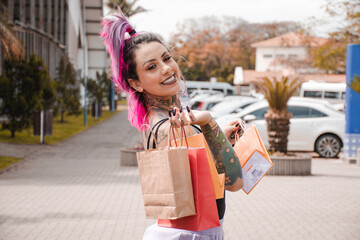Mulher tatuada segurando as compras