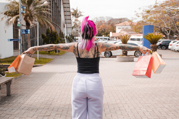 Mulher tatuada segurando as compras
