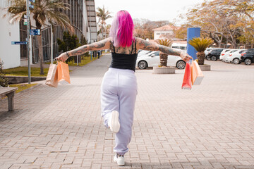 Mulher tatuada segurando as compras