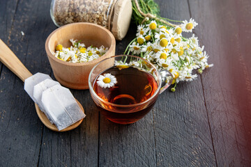 fresh chamomile flowers and a cup of herbal chamomile tea