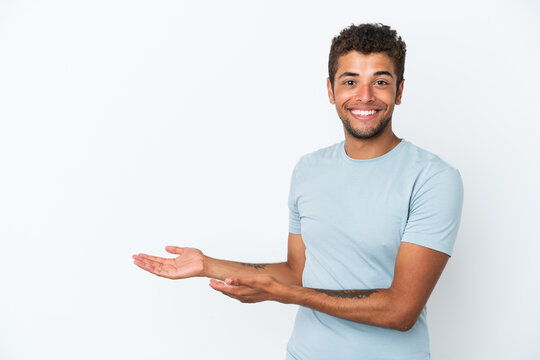 Young handsome Brazilian man isolated on white background extending hands to the side for inviting to come