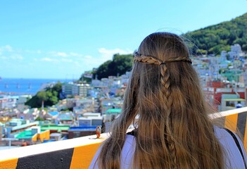 Long hair girl sightseeing looking at city and sea view