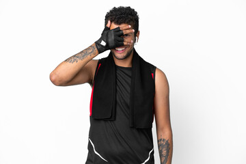 Sport brazilian man with towel isolated on white background covering eyes by hands and smiling