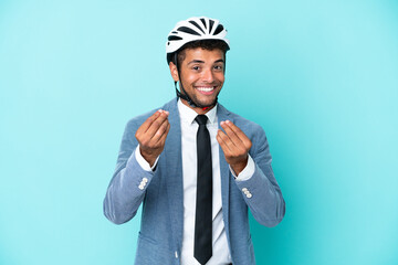 Young business Brazilian man with bike helmet isolated on blue background making money gesture