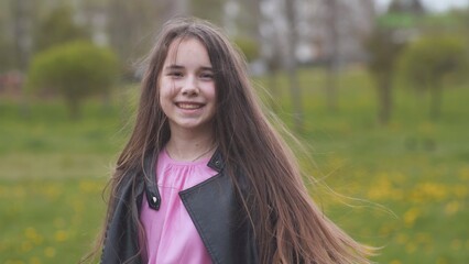 Fototapeta premium A teenage girl with long hair twirls and poses for the camera.