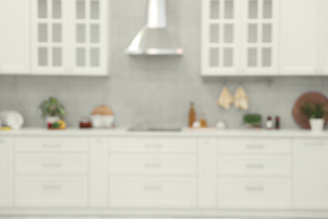 White cosy kitchen with furniture, blurred view. Interior design