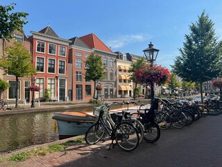 Obraz premium Beautiful view of parking with bicycles and plants near canal on city street