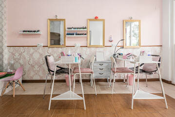 Nail fixing and treatment application and white pedicure stands in a beauty salon and wooden framed mirrors
