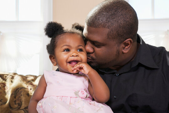 Portrait of Father Kissing Baby Girl on Cheek