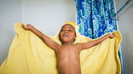Excited Boy coming out of Bath wearing Hooded Yellow Towel