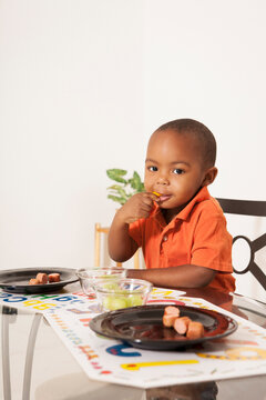 Boy Eating Lunch at Kitchen Table