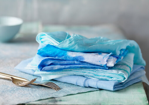 Stack of linens with cutlery on table, studio shot