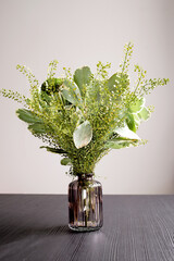 flower arrangement in a glass vase, a bouquet of mixed flowers from green chrysanthemums in the living room