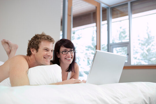 Couple in Bed using Laptop Computer