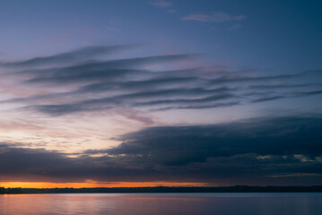 Cloudy dawn over lake in summer