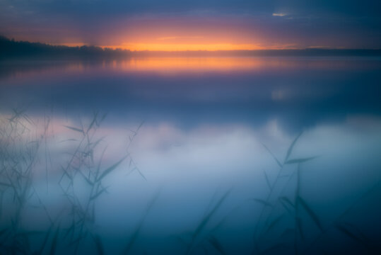 Misty dawn over lake in summer