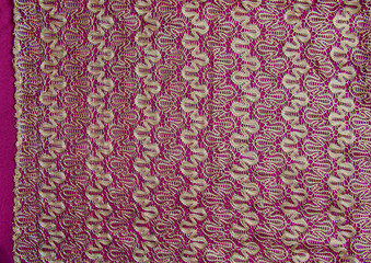 Beige openwork lace on a burgundy background