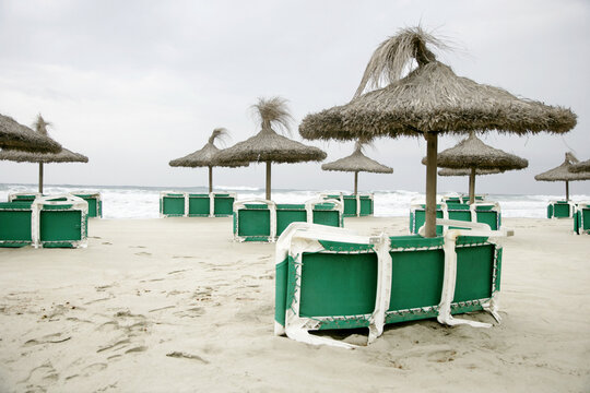 Tiki Umbrellas and Beach Chairs On Beach, Canyamel, Majorca, Spain