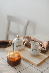 Homemade salted caramel sauce in jar on rustic wooden table.