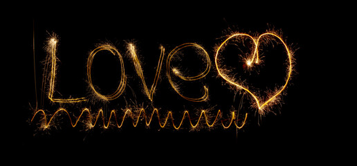 Inscription Love and heart of sparklers. Sparks of holiday lights on black background with heart and spiral.