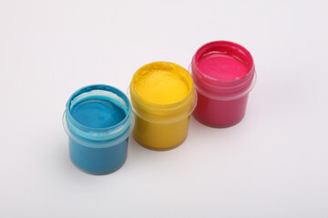 Acrylic paints in boxes on and white. Magenta, yellow blue colors.