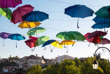 Fototapeta na wymiar Decoration with umbrellas floating over a street