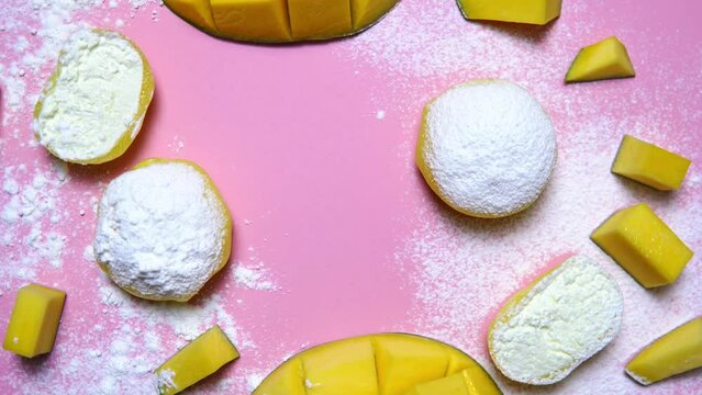 Tasty dessert Mochi with mango fruit on pink background 360 degrees rotation, close up. Traditional Japanese rice cake dessert