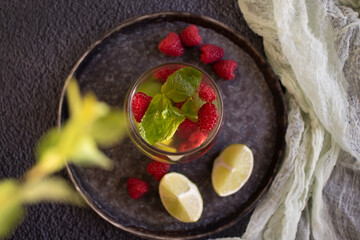 Cold water with mint, raspberry, lime on old background