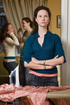 Teenaged Girl Doing Housework While Friends Party