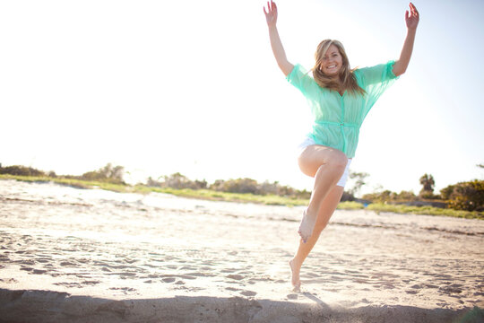 Young Woman Smiling and Jumping on Beach, Palm Beach Gardens, Palm Beach County, Florida, USA