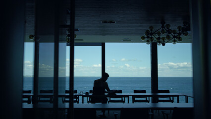 Businessman silhouette reading papers at sea view. Lawyer checking documents