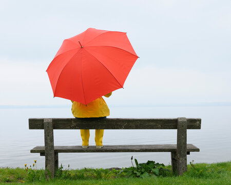 Women sitting on Bench with Umbrella, Lake Chiemsee, Bavaria, Germany