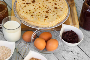 Stack of freshly prepared traditional pancakes with ingredients