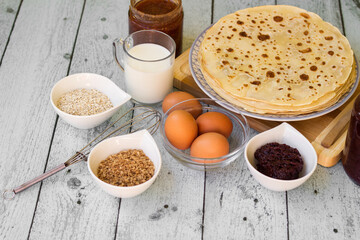 Stack of freshly prepared traditional pancakes with ingredients