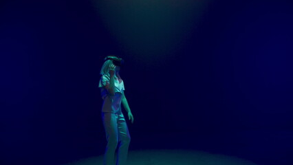 Joyful girl dancing augmented reality headset in neon lights. Happy gamer play