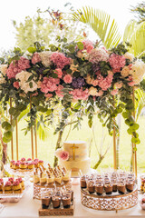 cake for the celebration of a first communion on a table full of desserts with decoration of roses,...